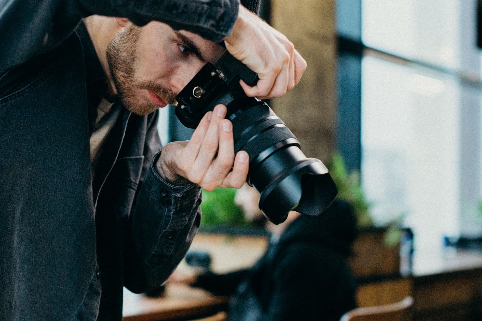 The photographer at work, eye to the viewfinder with a telephoto lens
