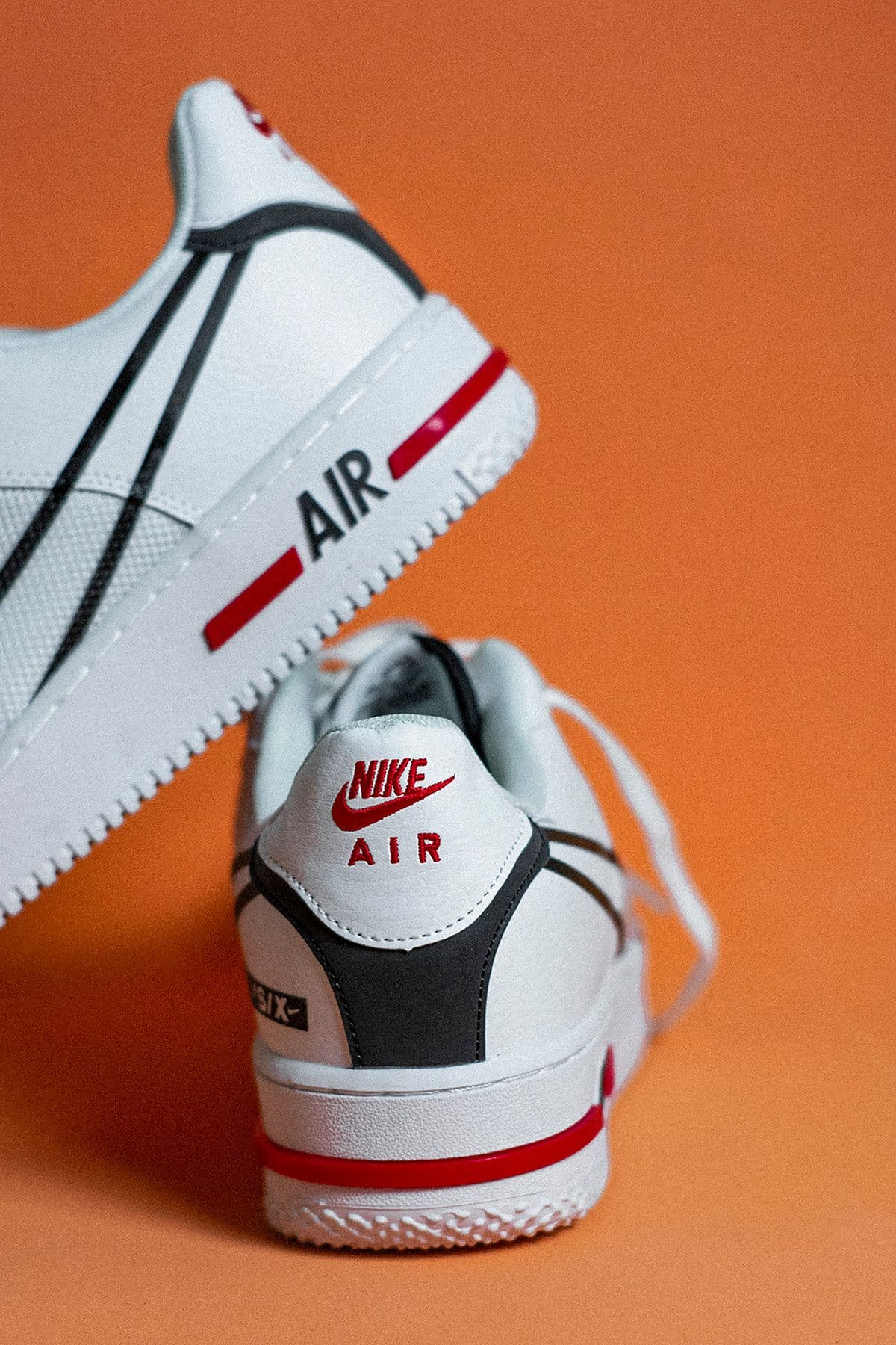 White sneakers in close-up on a saturated orange backdrop